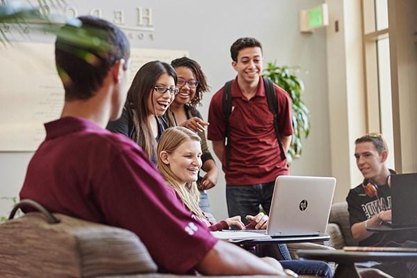 students gathered around a laptop